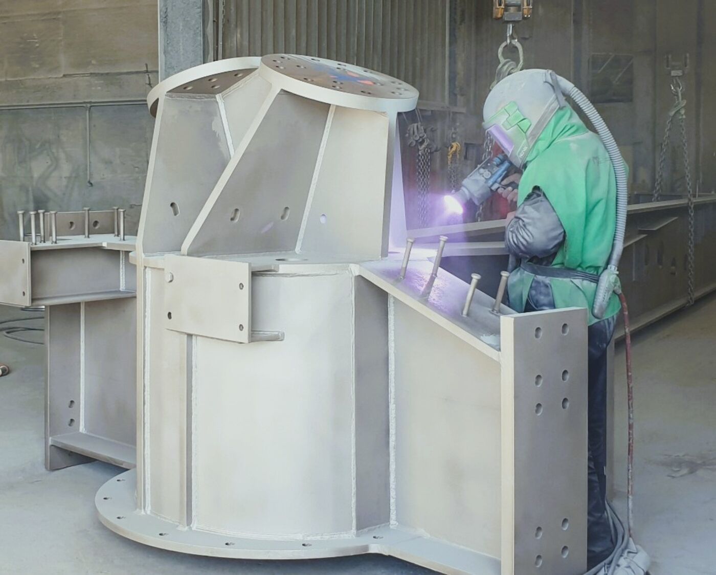 A blaster working on a large steel fabrication